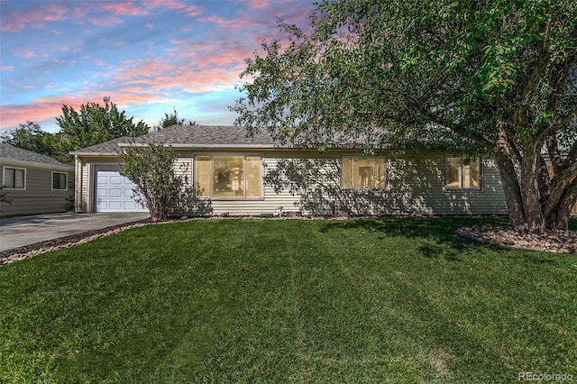 ranch-style house with a garage and a yard