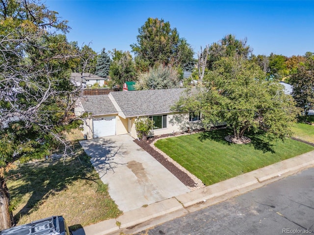 view of front of house featuring a garage, driveway, a front lawn, and a shingled roof