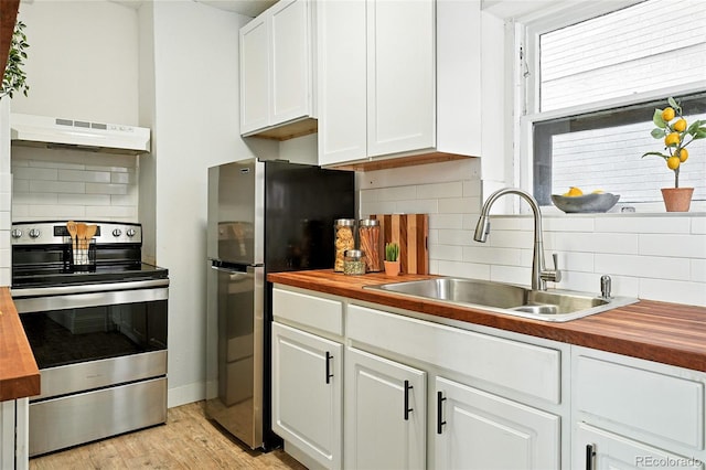 1137 N Sherman St Unit 17, Denver, CO 80203 - kitchen with appliances with stainless steel finishes, butcher block counters, premium range hood, and tasteful backsplash