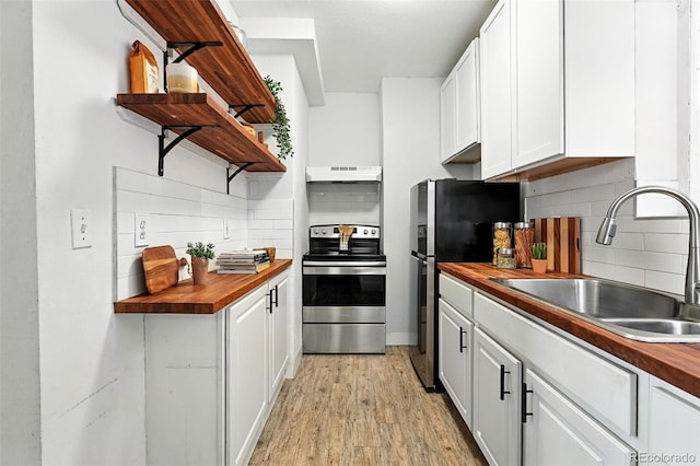 1137 N Sherman St Unit 17, Denver, CO 80203 - kitchen featuring open shelves, appliances with stainless steel finishes, butcher block countertops, premium range hood, and white cabinetry