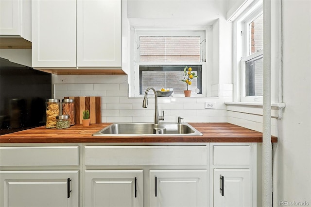 1137 N Sherman St Unit 17, Denver, CO 80203 - kitchen featuring wood counters, tasteful backsplash, and white cabinetry