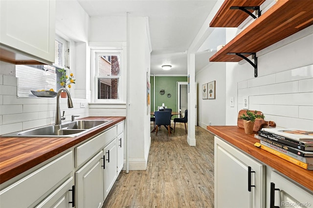 1137 N Sherman St Unit 17, Denver, CO 80203 - kitchen with butcher block counters, decorative backsplash, light wood-style floors, and crown molding