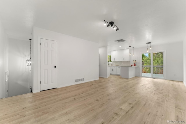 10687 W 107th Ave, Broomfield, CO 80021 - unfurnished living room with light wood finished floors and baseboards