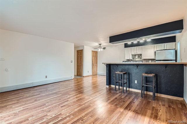 695 Manhattan Dr Unit 109, Boulder, CO 80303 - unfurnished living room featuring light wood finished floors, a ceiling fan, and baseboards