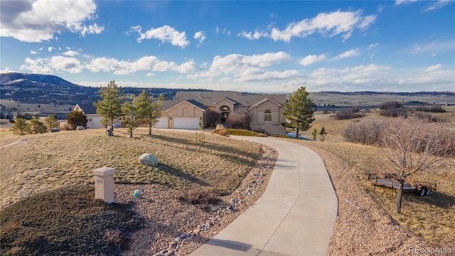 ranch-style house with a garage and a mountain view