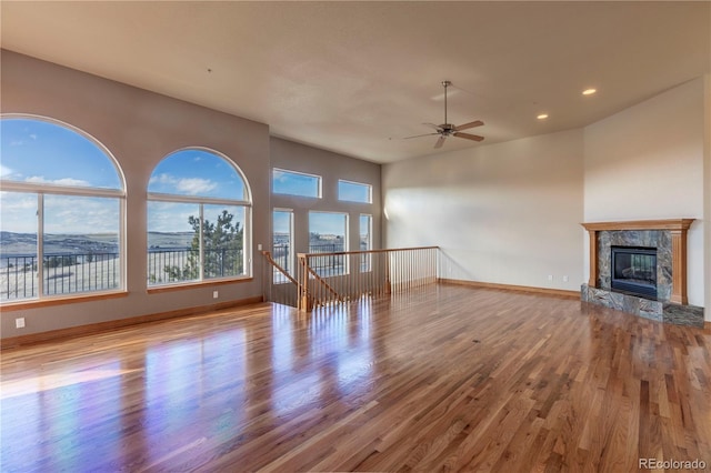 unfurnished living room with light hardwood / wood-style floors, ceiling fan, and a wealth of natural light