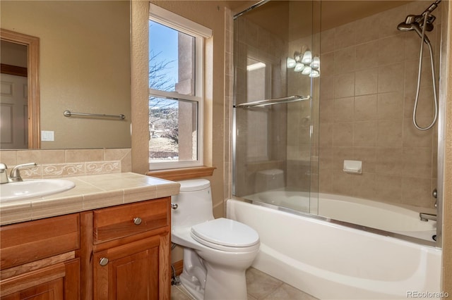 full bathroom with tile flooring, vanity, toilet, and bath / shower combo with glass door