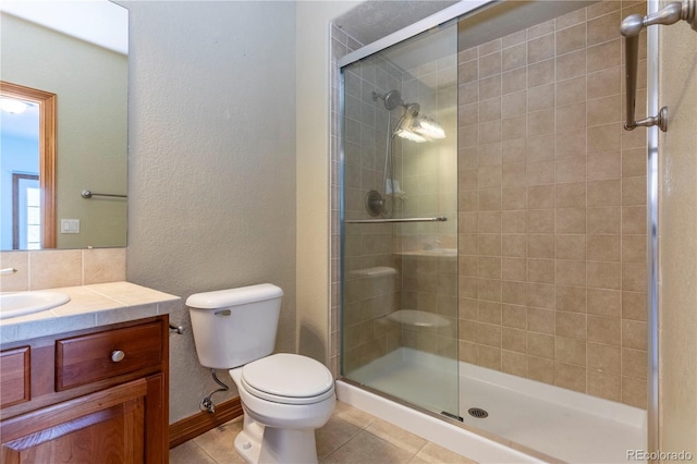 bathroom with a shower with shower door, toilet, tile flooring, and vanity