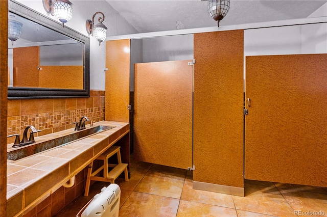 bathroom featuring a textured ceiling, decorative backsplash, tile patterned flooring, and radiator