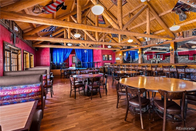 dining area featuring high vaulted ceiling, beamed ceiling, wooden ceiling, and hardwood / wood-style floors