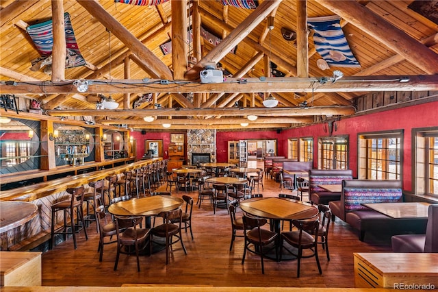 dining room with beam ceiling, hardwood / wood-style floors, and a healthy amount of sunlight