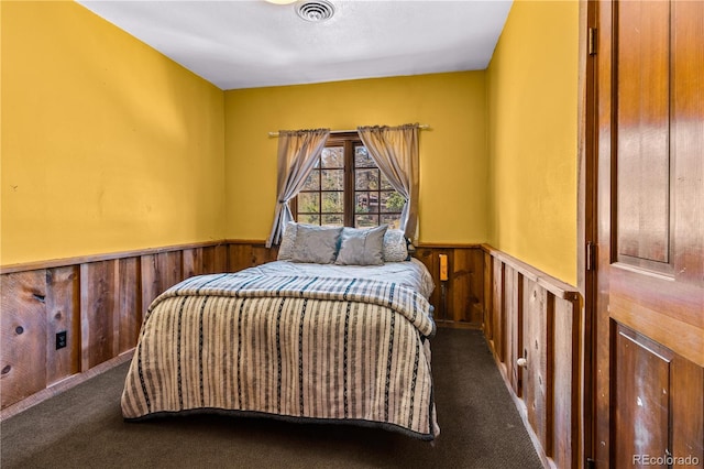 carpeted bedroom with wooden walls