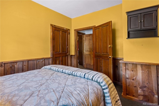 carpeted bedroom with wooden walls