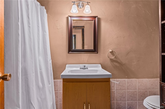 bathroom with tile walls, a shower with curtain, vanity, and toilet