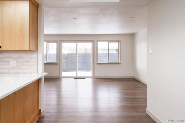 unfurnished living room featuring hardwood / wood-style floors, a textured ceiling, and a healthy amount of sunlight