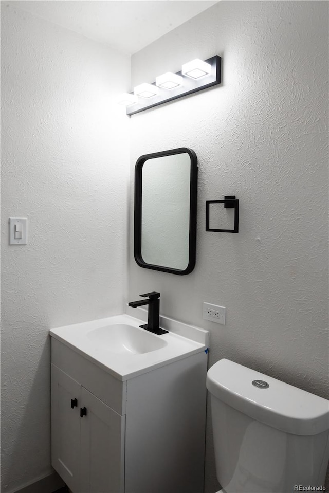 bathroom with toilet and vanity