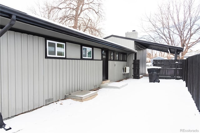 view of snow covered back of property