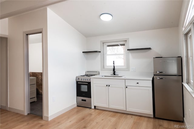 kitchen with sink, white cabinetry, stainless steel appliances, and light wood-type flooring