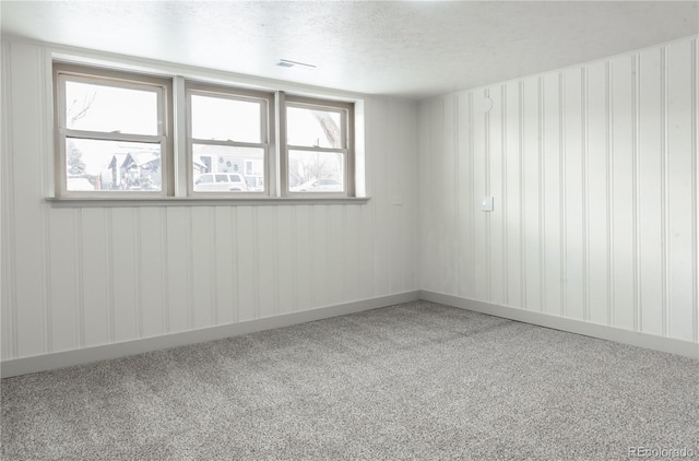 carpeted empty room with a textured ceiling