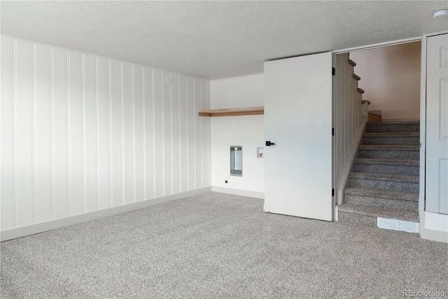 carpeted spare room featuring a textured ceiling