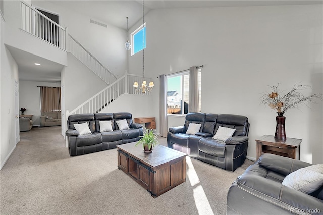 carpeted living room featuring a towering ceiling and a chandelier