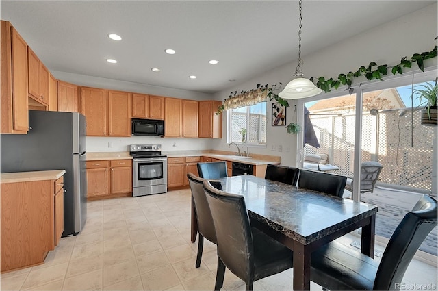 kitchen with sink, decorative light fixtures, and stainless steel appliances