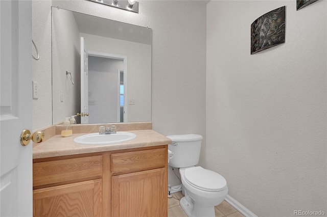 bathroom featuring vanity, tile patterned flooring, and toilet