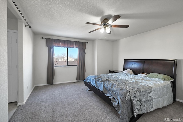 carpeted bedroom with ceiling fan and a textured ceiling