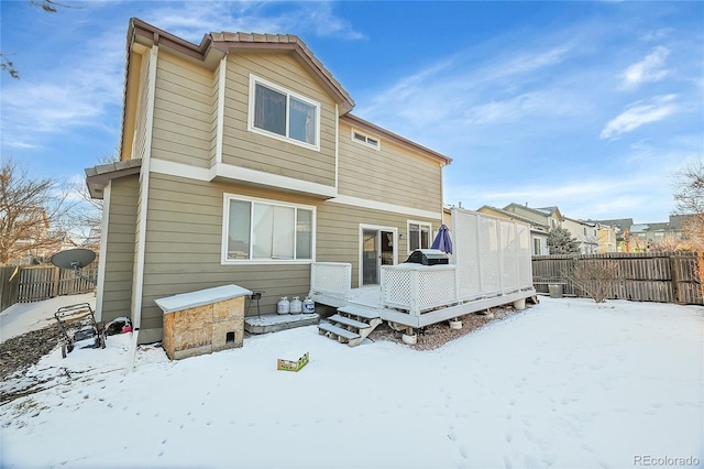 snow covered rear of property featuring a wooden deck