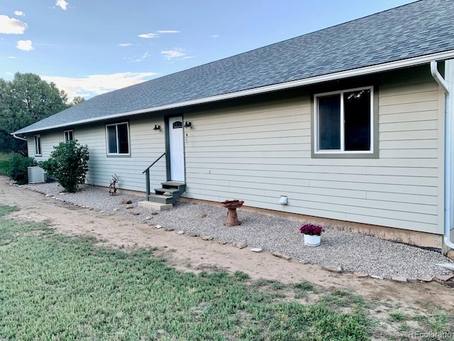 view of front of home featuring central AC unit and a front yard