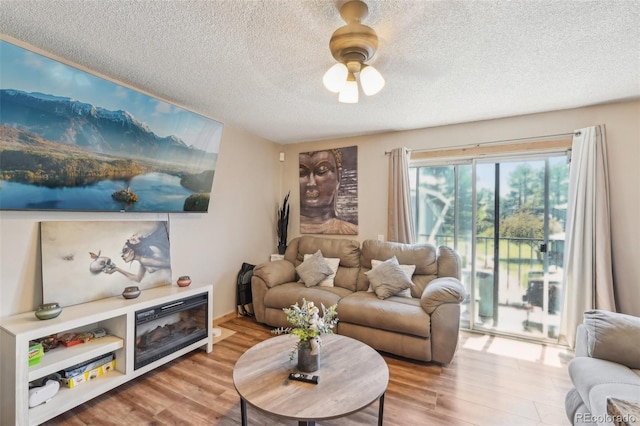 living area featuring ceiling fan, a textured ceiling, and wood finished floors
