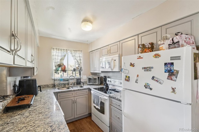 kitchen featuring white appliances, a sink, and wood finished floors