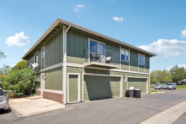 view of front of house featuring a balcony, board and batten siding, and an attached garage