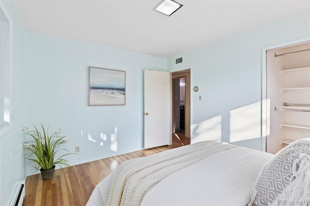 bedroom featuring hardwood / wood-style floors and a baseboard radiator