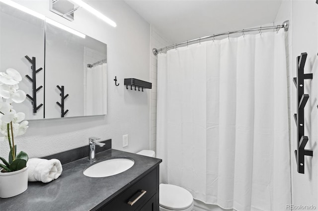 bathroom featuring walk in shower, vanity, and toilet