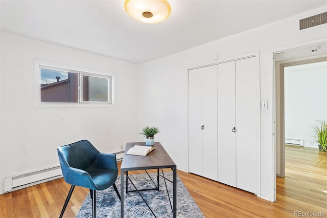 office area featuring light wood-type flooring and a baseboard heating unit