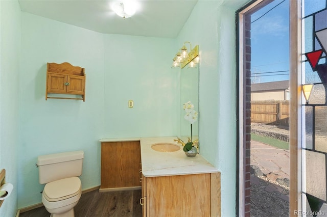 bathroom with wood-type flooring, vanity, and toilet