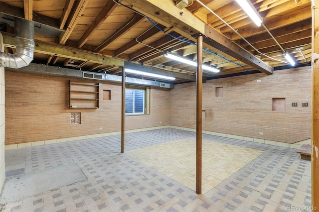 basement featuring brick wall