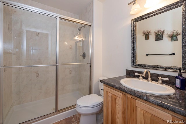 bathroom with tile patterned floors, vanity, toilet, and a shower with shower door