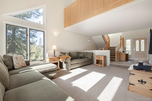 living room with light carpet, a high ceiling, and stairs