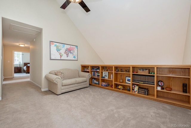 carpeted living area featuring attic access, baseboards, a ceiling fan, and lofted ceiling