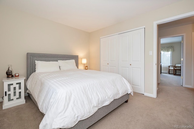 bedroom featuring light carpet, a closet, and baseboards