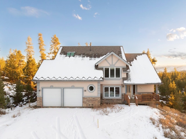 traditional-style home with stone siding, a garage, and stucco siding