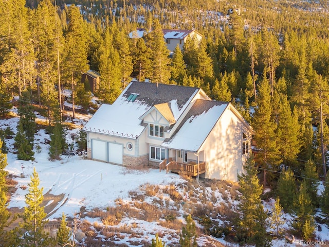 snowy aerial view featuring a forest view