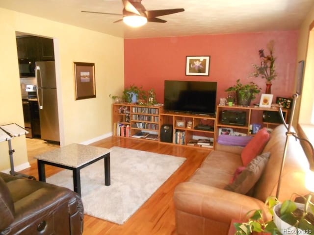 living room featuring hardwood / wood-style floors and ceiling fan