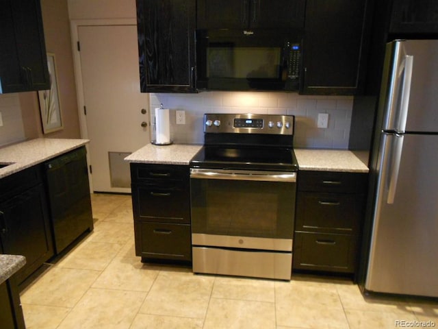 kitchen featuring light tile patterned flooring, tasteful backsplash, light stone countertops, and black appliances