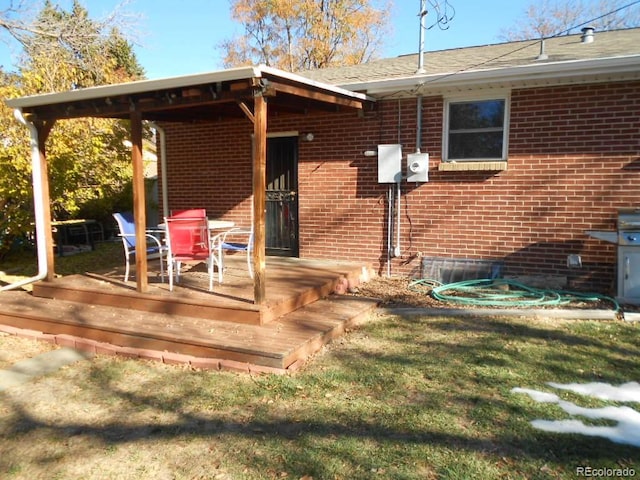 rear view of property with a yard and a wooden deck