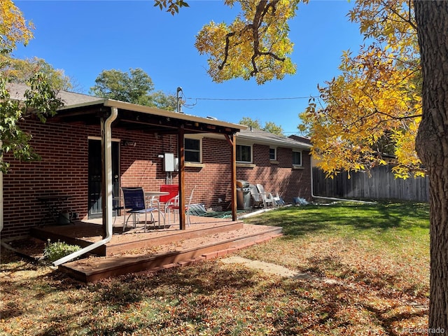 back of house featuring a lawn and a deck