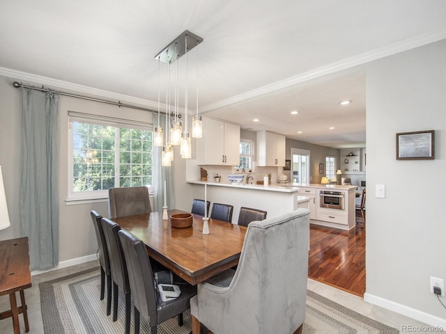 dining room featuring ornamental molding and light hardwood / wood-style floors