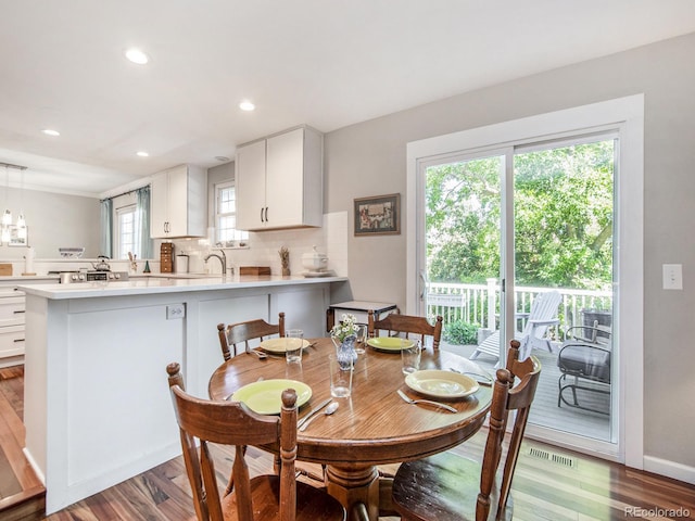 dining space featuring hardwood / wood-style flooring and sink